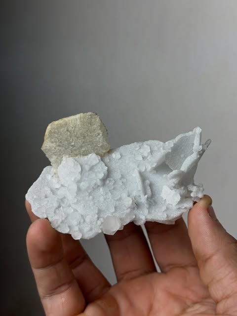 White natural crystal cluster with a warm-toned mineral cap